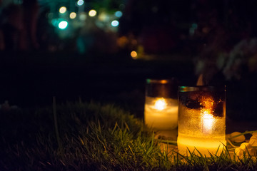 candles in a glass bottles lit up to celebrate All Soul's Day among Catholics