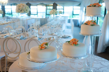 A multi-tiered wedding cake at a white and crystal themed wedding reception