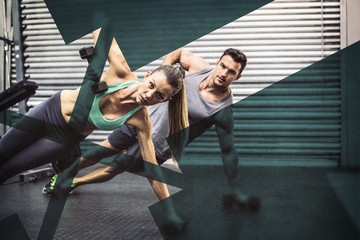 Smiling muscular couple doing side plank