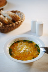 Soup at white ceramic plate at the table.