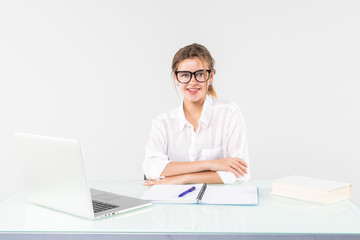 Happy businesswoman sitting at office desk, smiling isolated on white background.