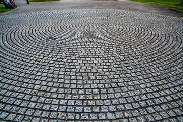 circular design cobblestone park ground surface with trees all around