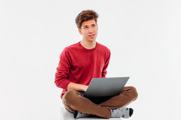 Teenager student thinking and working at laptop on white backgro