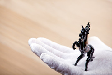 black horse figure hand white gloves table 