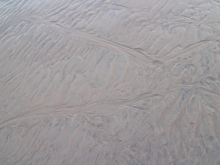 traces drawings from the waves in the sand