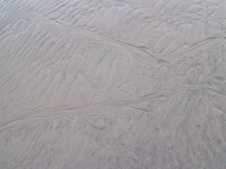 traces drawings from the waves in the sand