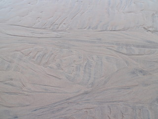 traces drawings from the waves in the sand