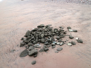 a pile of stones in the sand on the beach