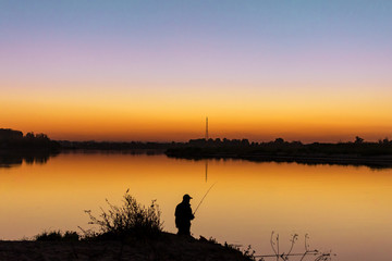 silhouette of a fisherman at sunset