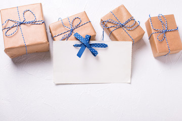 Empty  postcard and wrapped  gift boxes with presents  on textured background