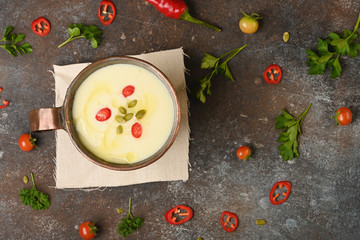 Celery root soup in copper cup on dark background. Horizontal.