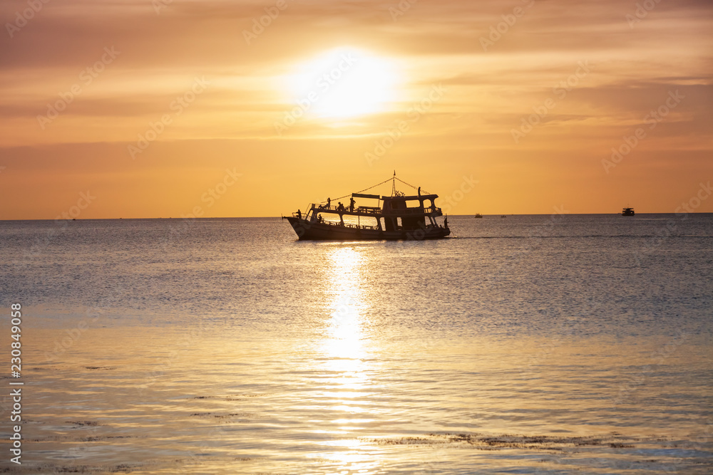 Wall mural sunset in the ocean with glowing sky and lonely boat