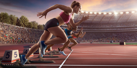 Female athletes sprinting. Three women in sport clothes run at the running track in professional stadium - obrazy, fototapety, plakaty