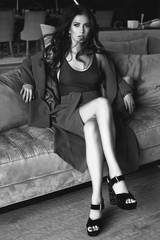 Gorgeous sensual brunette model in fashion suit relaxing on couch