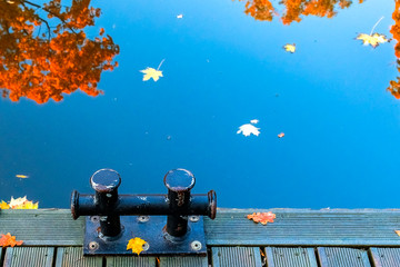 Colors of autumnal reflections in water of lake or river, city public park, Europe, EC