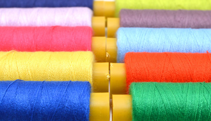 Sewing threads multicolored background closeup