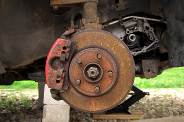 Fototapeta na wymiar rusty brake disc on a broken car in the yard