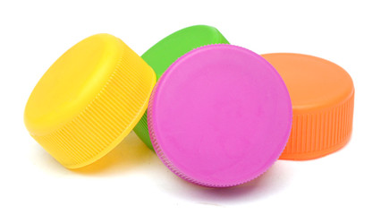 Bunch of multicolored used plastic bottle caps on white background
