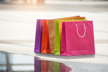 Shopper people placed colorful shopping bags after finished shopping at fashion mall.Gift and present in Paper bags is symbol of purchase and consumption in end of year