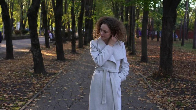 Young woman in autumn park. Autumn, curly girl in the park.