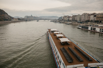 Cruiser arriving on the Danube river to the morning autumn Budapest in Hungary after the sunrise