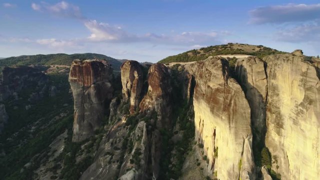 Rollback or pullback aerial shot of amazing natural mountain complex formation Meteora in Greece near beautiful antique or old city Kalabaka at perfect sunset gorgeous landscape