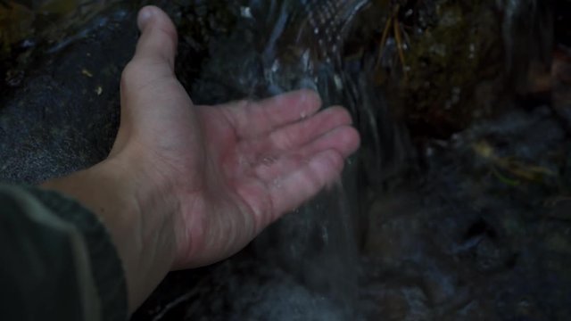 Touching fresh water stream in deep forest