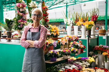Portrait of senior woman sales flowers on local flower market