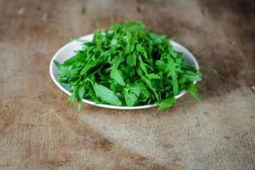 Arugula - fresh salad (rucola) on a gray background. top view. copy space