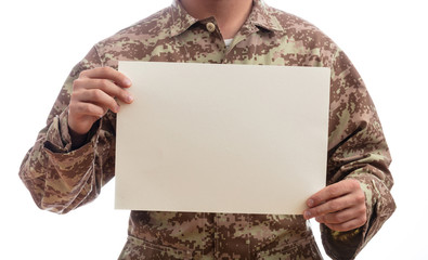 Young soldier holding a blank paper standing on white background