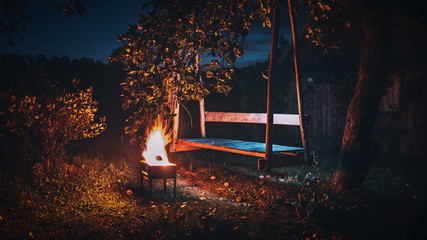 Garden swing and a fire burning in front of them.