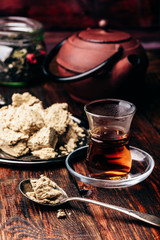 Black tea in armudu glass and spoonful of halva