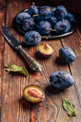 Ripe plums with leaves and knife