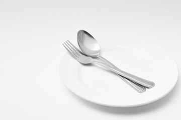 fork and spoon on a white ceramic dish