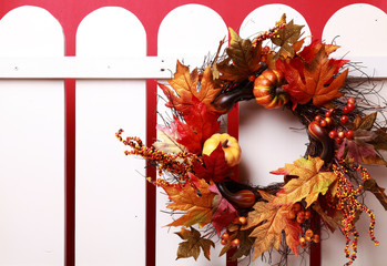 Fall wreath hanging on a white fence