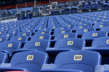  Empty rows and sections of red and blue seats in a sports stadium.