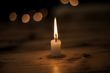 One light candle burning brightly in the black background