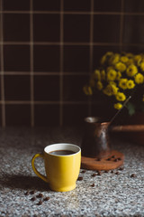 Fototapeta na wymiar coffee cup with flowers in the kitchen