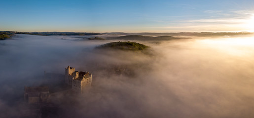 Chateau Beynac in fog in the early morning Perigord Noir Dordogne France