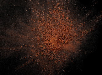 pile cocoa powder pile  on black background, top view