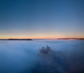 Chateau Beynac in fog in the early morning Perigord Noir Dordogne France