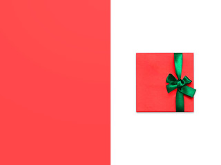 Gift boxes Christmas decor Top view Red gift box with bright green ribbon on two-tone background Photo mockup with space for text