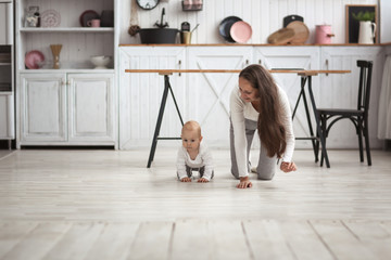 mother and baby crawling together on the floor