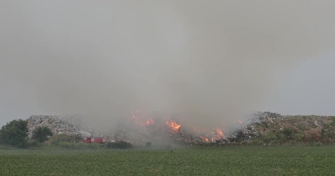 Firefighters at Garbage Landfill Fire With Smoke Pollution