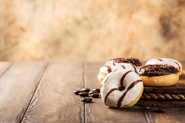 Glazed mini gluten free donuts with coffee candies on wooden background. Party food concept with copy space.