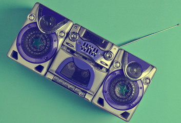 Retro tape recorder on mint-colored pastel background. Technology 80s. Top view..
