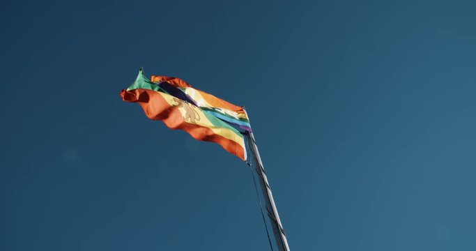 Rastafarian flag and rainbow peace flag on pole