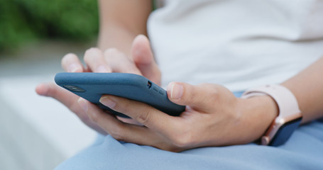 Woman use of mobile phone in city park