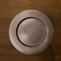 Silver  glistening plate, isoled on wooden background.  Top view.