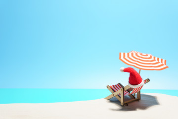 Creative composition of Santa hat on beach